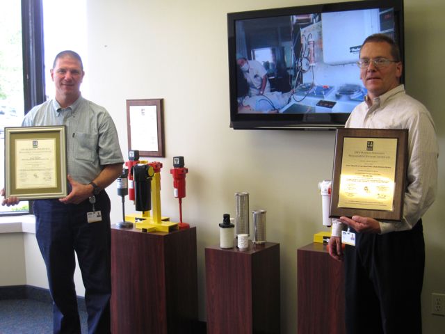 Marvin Walsh and Ron Nelson display Parker’s ISO 9001 Certifications.